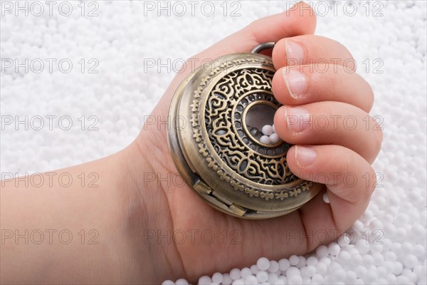 Retro style pocket watch in hand on white background