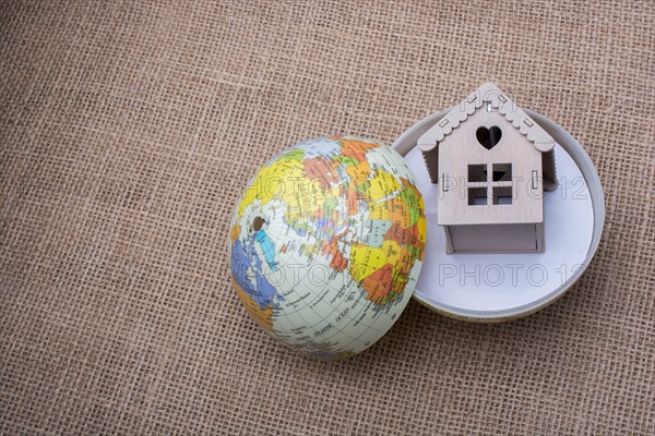 Model house and a globe on a linen canvas