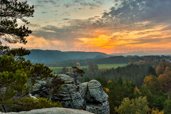 Sunrise in the mountains with a rocky peak in the foreground