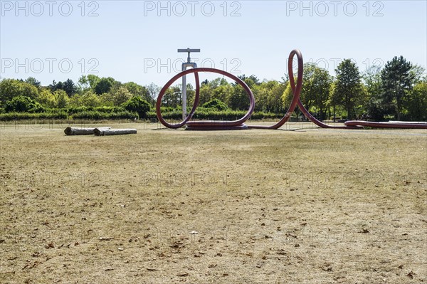 Withered meadow and sculpture of a water tap