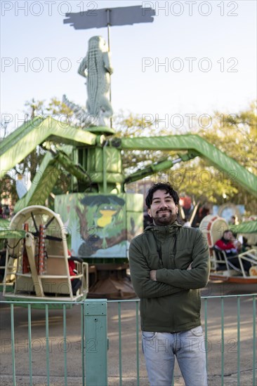 Portrait of latino man posing happy in an amusement park