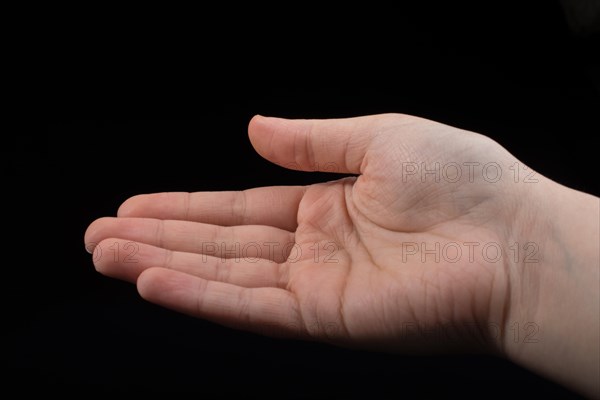 Five fingers of a child hand partly seen in black background