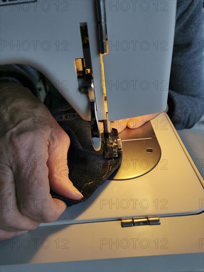 Hands of woman with a sewing machine