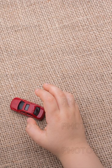 Toy car as a transportation devices in hand on a canvas background