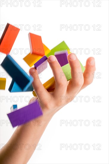 Falling colorful domino onto a hand