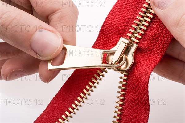 Hand holding color zipper on a white background