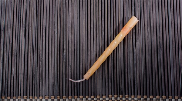 Colorful birthday candle placed on a straw mat