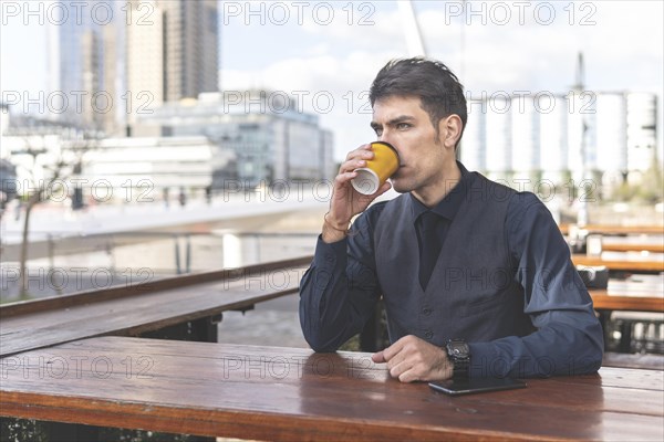 Businessman sitting at an outdoor bar having a coffee