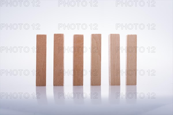 Wooden Domino Blocks in a line on a white background