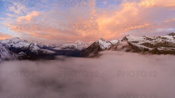 Aerial view over the sea of fog in front of sunrise over the Maloja Pass in autumn