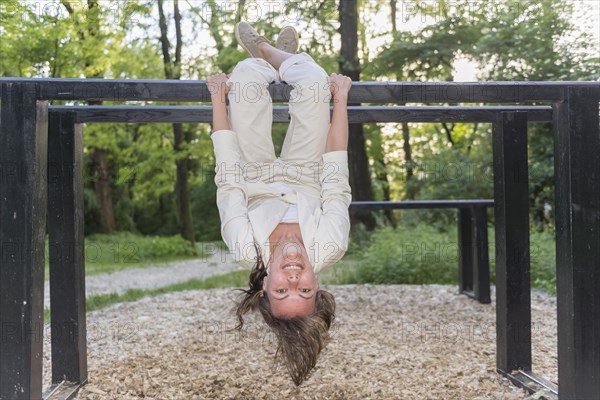 Woman Hanging Upside Down on Wood Bars