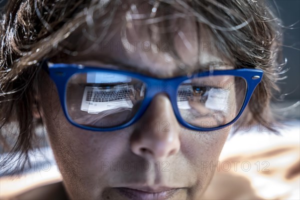 Beautiful Business Woman Face with Eyeglasses Reflection When She is Working on Her Laptop in Switzerland