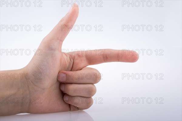 Hand making a gun gesture on a white background