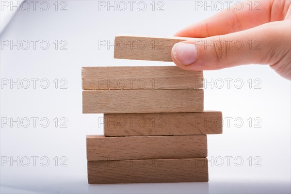 Hand holding wooden domino on a white background