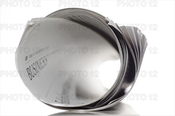 Rolled financial newspaper with white background
