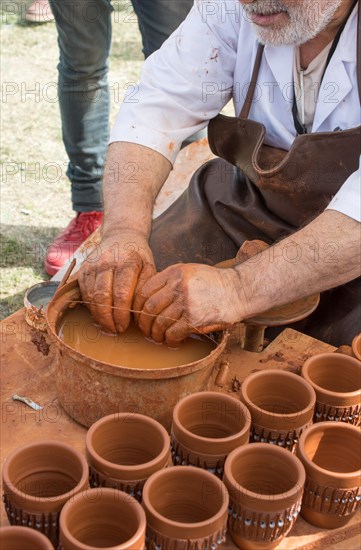 Potter`s hands shaping up the clay of the pot