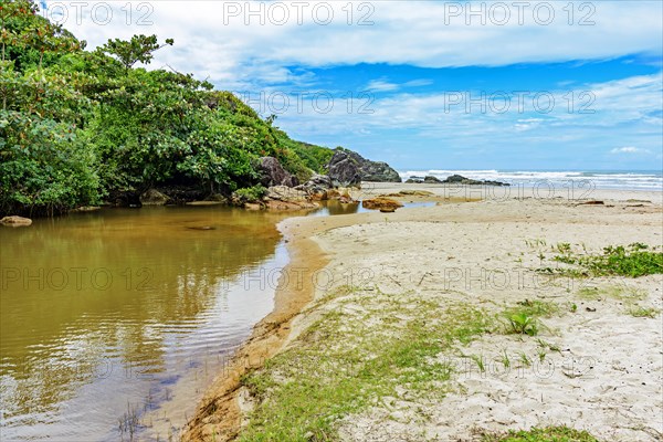 River going towards the sea with the sand