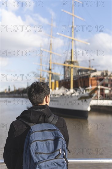 Back view of a tourist posing in front of a boat in Puerto Madero