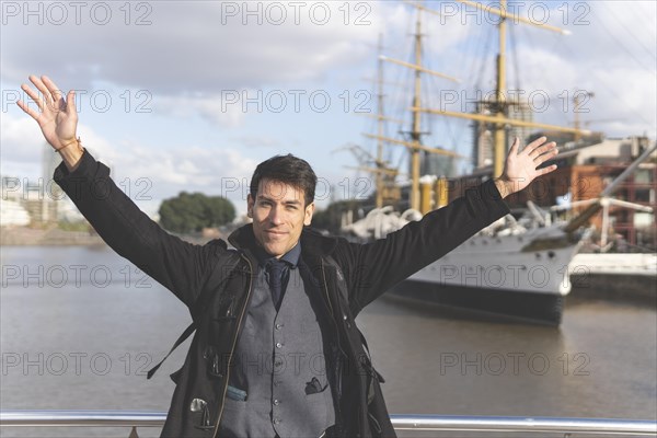 Happy tourist posing in front of a boat in Puerto Madero
