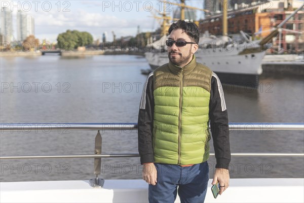 Happy tourist posing in front of a boat in Puerto Madero