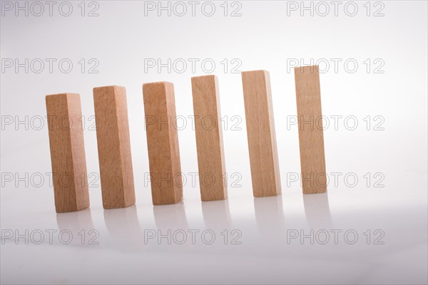 Wooden Domino Blocks in a line on a white background