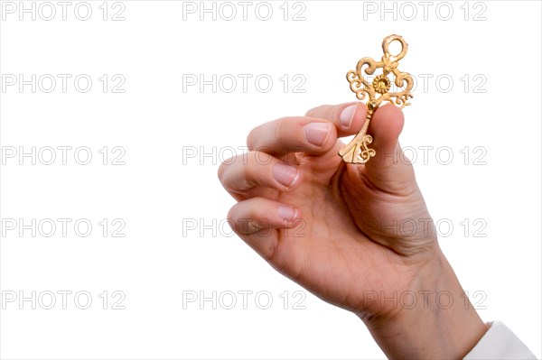 Hand holding a retro styled metal key on a white background