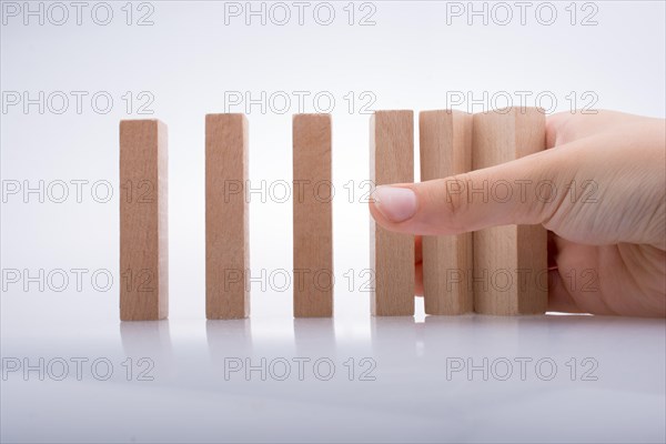 Hand holding wooden domino on a white background