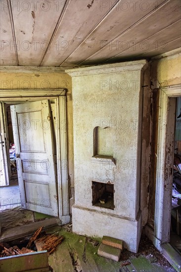 Interior in an old abandoned ruined house with a masonry heater