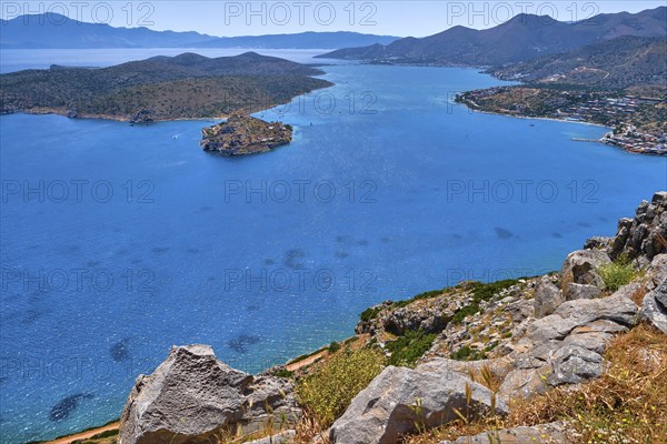 Aerial view of clear sea waters of harbor between Spinalonga island and peninsula