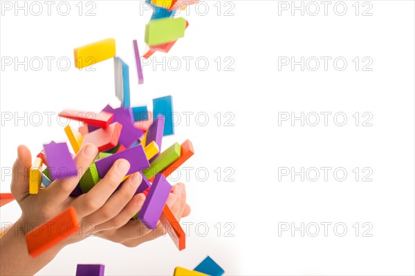 Falling colorful domino onto a hand