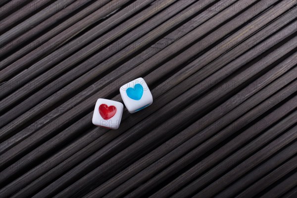 Colorful heart shaped love cubes on a straw mat