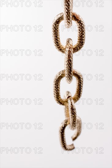 Gold color metal chain on white background