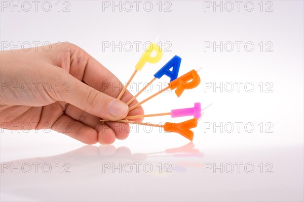 Color candles in hand on sticks write the word party
