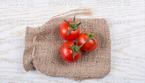 Little canvas sack and red ripe tasty fresh cherry tomatos