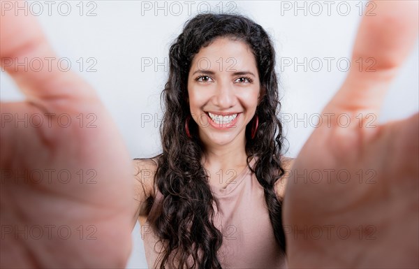 Happy girl taking a selfie looking at the camera isolated. Smiling young woman taking a self portrait isolated