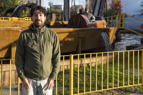 Portrait of latino man posing happy in an amusement park