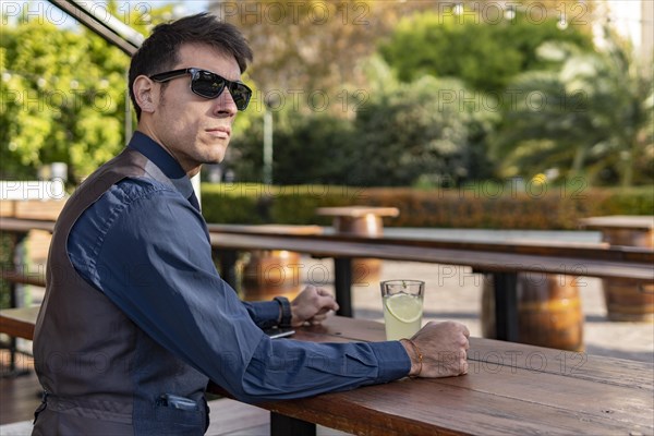 Businessman sitting at an outdoor bar drinking lemonade