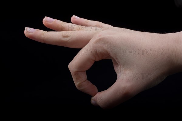 Hand gesturing sign ok okay agree on black background