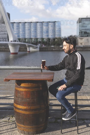 Latin tourist drinking beer at an outdoor bar in Puerto Madero