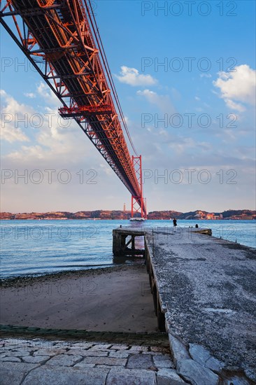 View froum under of 25 de Abril Bridge famous tourist landmark over Tagus river