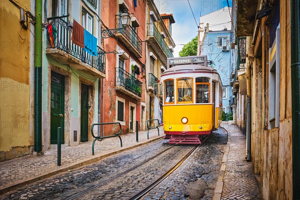 Famous vintage yellow tram 28 in the narrow streets of Alfama district in Lisbon