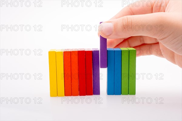 Hand holding color dominoes on a white background