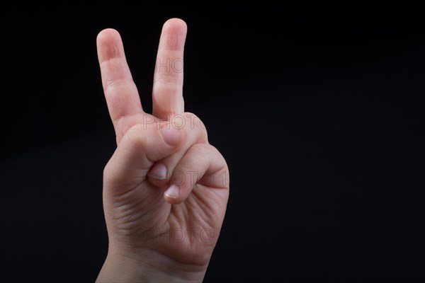 The sign of victory and peace in black background