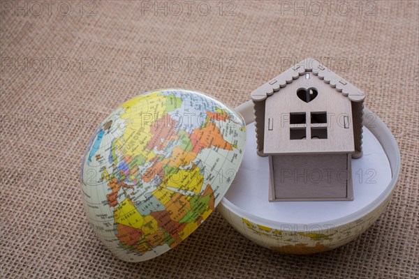 Model house and a globe on a linen canvas