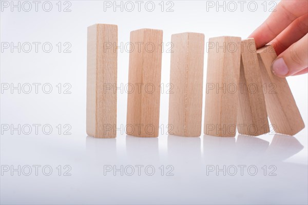 Hand holding wooden domino on a white background