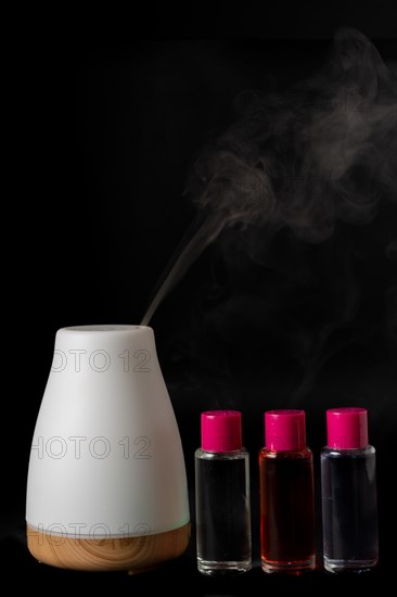 Aroma humidifier steaming with scent pots isolated on a black background