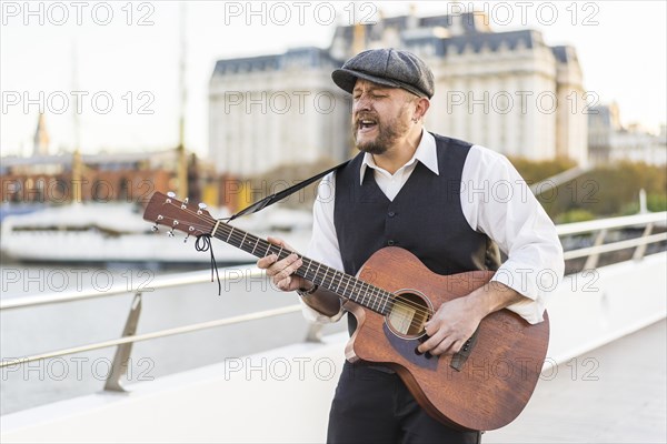 A street musician performing classic songs on guitar