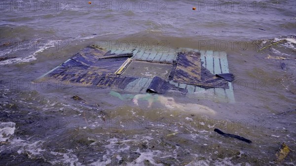 Part of wall of house floats near shore