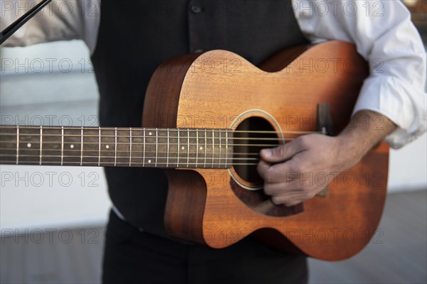 Professional guitarist plays guitar outdoors. Musician plays a classical guitar in the park