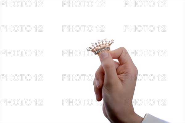 Golden color crown with pearls in hand on a white backgound